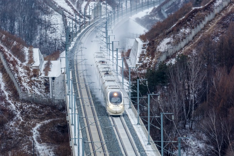 JILIN, CHINA - DECEMBER 14: A high-speed train runs along a railway after a snowfall on December 14, 2022 in Jilin, Jilin Province of China. (Photo by Zhang Jingfeng/VCG via Getty Images)
