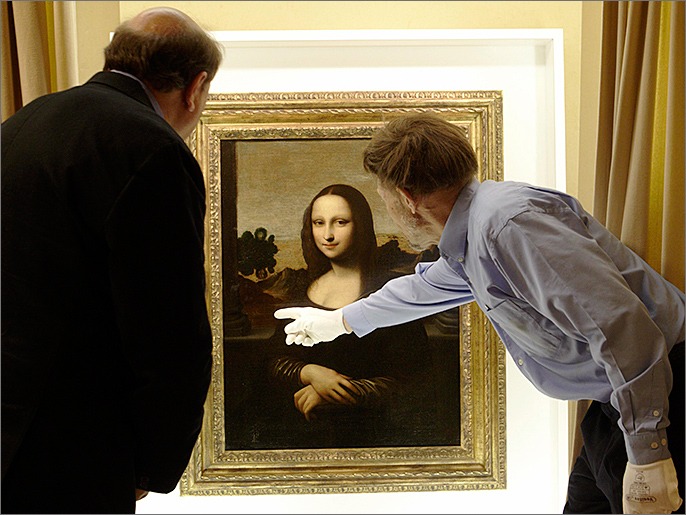 David Feldman (R) , vice president of the Mona Lisa Foundation, shows similarities on a painting attributed to Leonardo da Vinci and depicting Mona Lisa to his brother Stanley, an art historian, during a preview presentation in a vault in Geneva in this September 26, 2012 file photo. New tests on the painting billed as the original version of the Mona Lisa, Leonardo da Vinci's iconic 15th century portrait, have produced fresh proof that it is the work of the Italian master, the Swiss-based Mona Lisa Foundation said on February 13, 2013. To match story ART-MONALISA/ REUTERS/Denis Balibouse/Files (SWITZERLAND - Tags: SOCIETY)