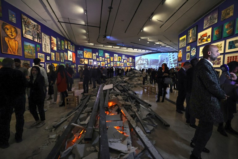 People visit the 'This Is Not An Exhibition' section displaying paintings by Gazan artists, as the Palestinian Museum reopened in Birzeit in the occupied West Bank on February 11, 2024. - The museum reopened following closure in the aftermath of the October 7 attacks and ensuing conflict with Israel, with several exhibits showcasing Gazan art and heritage from collections and individuals in the West Bank. (Photo by Zain JAAFAR / AFP)