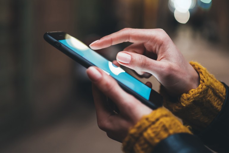 point finger on screen mobile phone closeup, person texting text message, hipster touch blue screen on smartphone light night city, girls using in hands cellphone close up, online internet