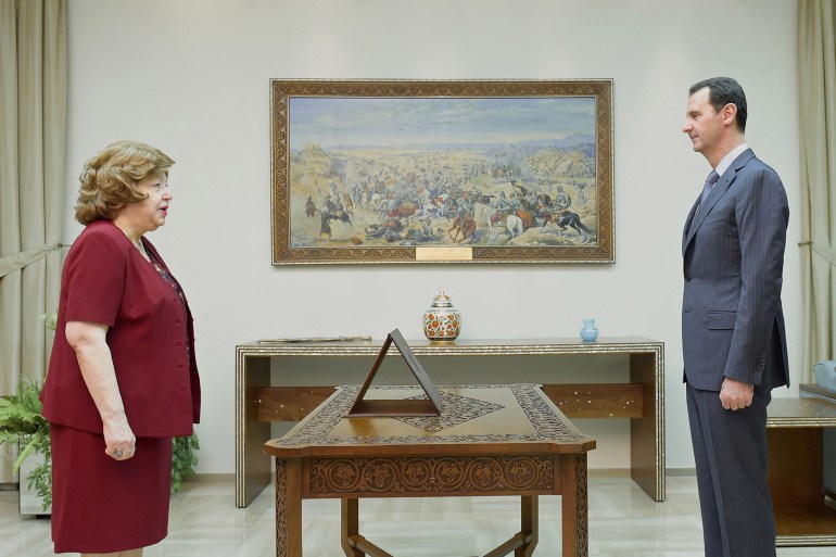 A handout picture released by the official Syrian Arab News Agency (SANA) shows Najah al-Attar (L) standing in front of Syrian President Bashar al-Assad during her swearing-in ceremony for her reappointment to the position of vice-president, on July 20, 2014, in the capital Damascus. Assad has reappointed Najah al-Attar as his vice president but made no mention of his other deputy and veteran diplomat Faruq al-Sharaa. AFP PHOTO/HO/SANA === RESTRICTED TO EDITORIAL USE - MANDATORY CREDIT "AFP PHOTO / HO / SANA" - NO MARKETING NO ADVERTISING CAMPAIGNS - DISTRIBUTED AS A SERVICE TO CLIENTS === (Photo by SANA / AFP)