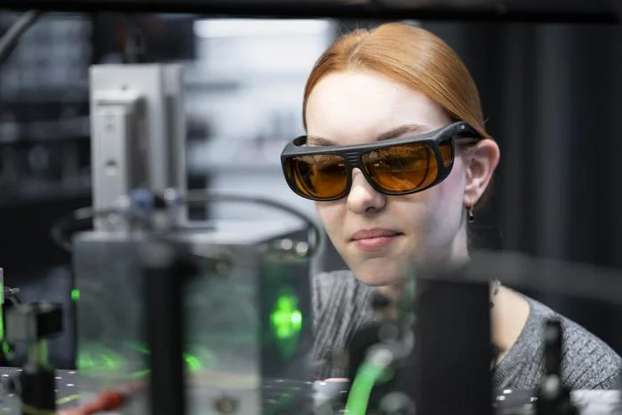 "ملقط من الضوء".. كيف يساعد الليزر العلماء على كشف سر البرق؟ الباحثة أندريا ستولنر ترتدي نظارات واقية، وتلقي نظرة خاطفة على غرفة التجارب (معهد العلوم والتكنولوجيا النمساوي)