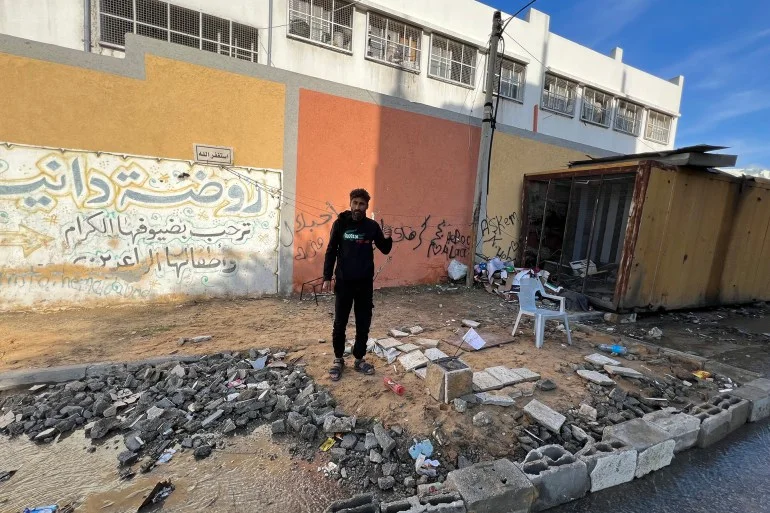 علي الضبة يجهز أرضية جزء من رصيف مدرسة لإقامة خيمته عليه بعد أن فقد منزله خلال الحرب ولم يجد متسعا في مراكز الإيواء الرسمية